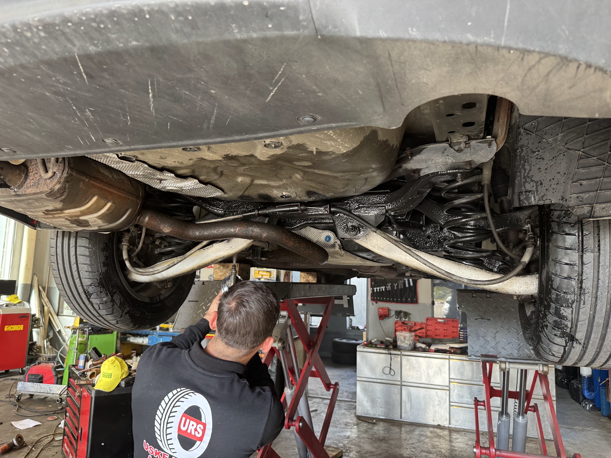 Mitarbeiter von Uske Reifen & Kfz Service bei der Arbeit unter einem Fahrzeug